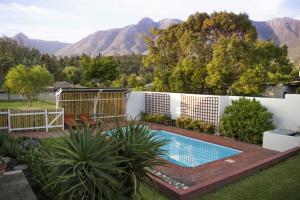 a swimming pool in a yard with mountains in the background at 33 Berg Selfcatering in Swellendam
