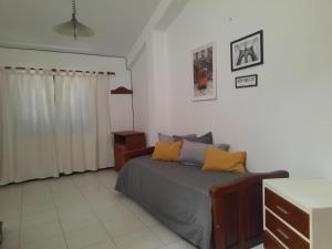 ein Schlafzimmer mit einem Bett mit gelben Kissen darauf in der Unterkunft Departamento Coronel Arias in San Salvador de Jujuy