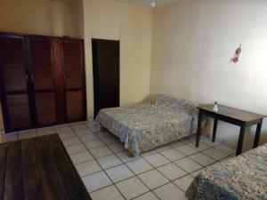 Habitación con 2 camas y mesa. en CASA PLAYITA MELAQUE, en San Patricio Melaque