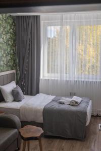 a bedroom with two beds and a couch and a window at Hotel Yaman in Eberswalde