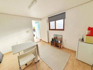 a white room with a desk and a refrigerator at Private House Isu in Seoul