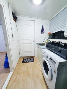 a kitchen with a washing machine and a door at Private House Isu in Seoul
