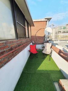 2 stoelen op een balkon met groen gras bij Private House Isu in Seoul