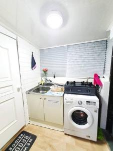 a kitchen with a washing machine and a sink at Private House Isu in Seoul