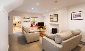a living room with two couches and a tv at Fern Cottage in Ambleside