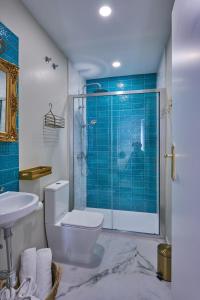 a bathroom with a toilet and a shower with blue tiles at Casa Pureza in Seville