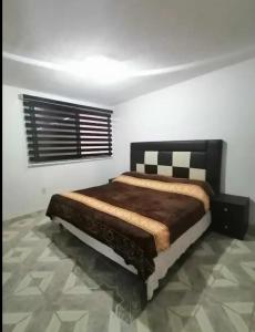 Hogar amplio y acogedor في إكسميكيلبان: غرفة نوم مع سرير في غرفة مع نافذة