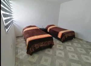 two beds sitting in a room with a wall at Hogar amplio y acogedor in Ixmiquilpan