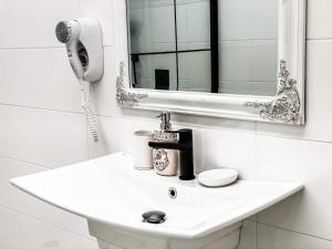 a white bathroom with a sink and a mirror at Diamond Villas in Enina