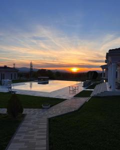 a sunset over a patio with the sun setting at Diamond Villas in Enina