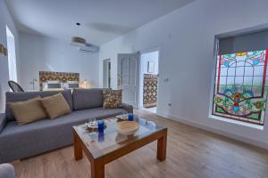 een woonkamer met een bank, een tafel en een glas-in-loodraam bij Casa Pureza in Sevilla