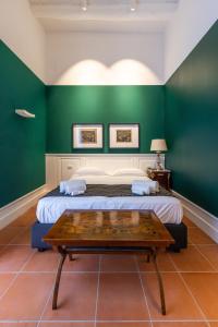 a bedroom with green walls and a bed with a wooden table at Corte Satriano Residence in Naples