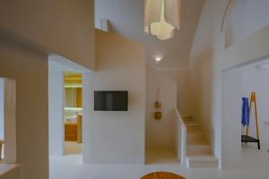 a living room with a tv on a wall at Elements Cave Suites in Megalokhori