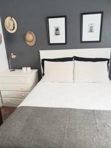 1 dormitorio con 1 cama blanca y 2 cuadros en la pared en Las Cañitas en Buenos Aires