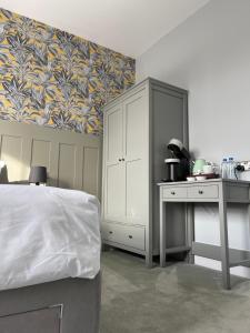 a bedroom with a bed and a cabinet and a desk at The Bulls Head Inn in Ewhurst