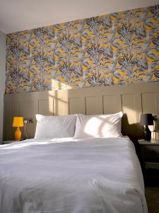 um quarto com uma cama grande e papel de parede azul e amarelo em The Bulls Head Inn em Ewhurst