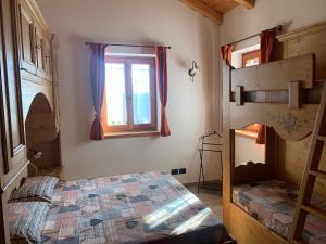 ein Schlafzimmer mit einem Etagenbett und einem Fenster in der Unterkunft Regensburgerhof in Castello Tesino