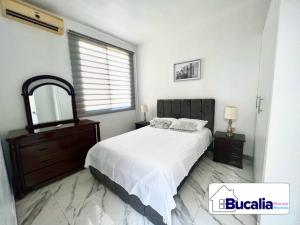 Schlafzimmer mit einem Bett, einer Kommode und einem Spiegel in der Unterkunft Bucalia House Machala in Machala