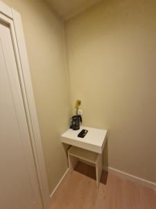 Una pequeña habitación con una mesa blanca con una cámara. en Le Petit Palü- Barco, en Madrid