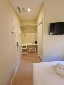 um quarto com uma cama, uma escrivaninha e uma TV em Le Petit Palü- Barco em Madrid mais 7 fotografias