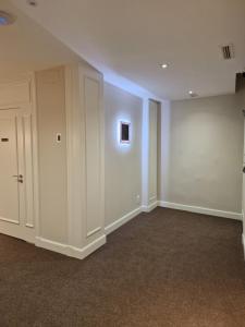 um quarto vazio com paredes brancas e armários brancos em Le Petit Palü- Barco em Madrid