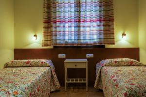 A bed or beds in a room at Hostal Parque Natural