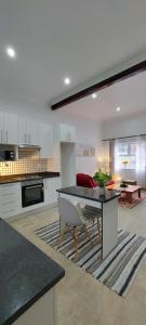 a kitchen and living room with a table and a couch at MaeStorm GardensAfrican apartement in East London