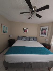 a bedroom with a large bed with a ceiling fan at ROSI Ocean Sand Hotel Apt (@Sandcastles) in Ocho Rios