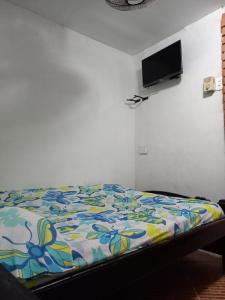 1 dormitorio con 1 cama con un edredón colorido en Hostal #10-33 en Cartagena de Indias
