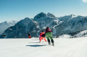 a group of people skiing down a snow covered mountain at Ferienhaus Mörtl in Tröpolach