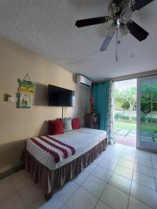 - une chambre avec un lit et un ventilateur de plafond dans l'établissement ROSI Ocean Sand Hotel Apt (@Sandcastles), à Ocho Rios