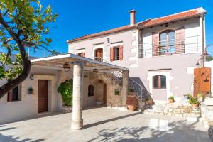 een groot wit huis met een pilaar op de binnenplaats bij Cretan Lux Villa Heated Pool in Gavalochori
