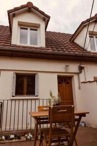 une table et une chaise en bois devant une maison dans l'établissement Appartement duplex : Le Cosy, à Montgeron