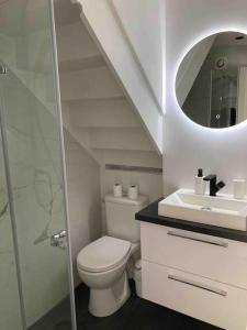 a white bathroom with a toilet and a sink at Appartement duplex : Le Cosy in Montgeron