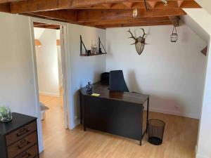 ein Büro mit einem Schreibtisch und einem Computer in einem Zimmer in der Unterkunft Appartement duplex : Le Cosy in Montgeron