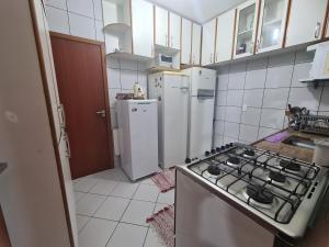 a kitchen with a stove and two refrigerators at Aconchego da Serra in Teresópolis