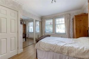 マッセルバーグにあるSuperb 5 bedroom Villa 16 mins from City Centreの大きなベッドと鏡のある寝室