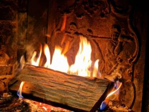 a fire in a stone oven filled with wood at Place Royale pour 10 à 12 personnes à 30m des pistes de Ski et Vtt in Métabief