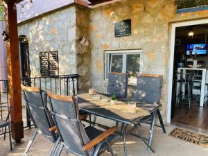 einen Holztisch und Stühle auf einer Terrasse in der Unterkunft Kuća za odmor “Dida” in Stinica