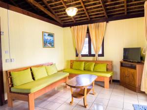 a living room with two couches and a table at MOOREA - The Golden Reef Bungalow Nuku Hiva in Temae