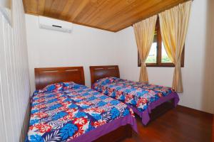 1 dormitorio con cama y ventana en MOOREA - The Golden Reef Bungalow Nuku Hiva en Temae