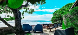 MOOREA - The Golden Reef Bungalow Nuku Hiva في Temae: طاولة وكراسي يجلسون بجوار الشاطئ