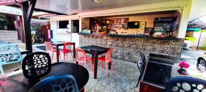 un bar con mesas y sillas rojas en un restaurante en MOOREA - The Golden Reef Bungalow Moorea en Temae