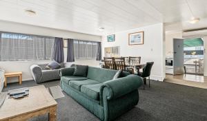 a living room with a couch and a table at Kowhai Motel Rotorua in Rotorua