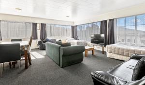 a large living room with couches and a tv at Kowhai Motel Rotorua in Rotorua