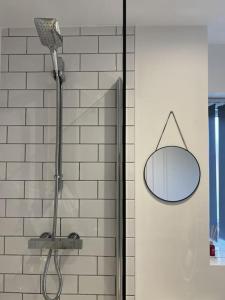 a shower with a round mirror on a wall at Erasmus House - 3 Bedrooms - City Centre, Netflix, WIFI, Free Private Parking in Derby