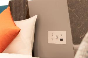 um interruptor de luz ao lado de uma almofada numa cama em karaksa hotel colors Tokyo Yaesu em Tóquio