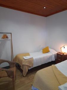 ein Schlafzimmer mit 2 Betten und einem Tisch mit einer Lampe in der Unterkunft Refúgio das Pedreiras in Santa Rita