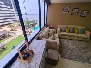 una sala de estar con una gran ventana con vistas al océano en EcuSuites Vista Río Puerto Santa Ana Wyndham, en Guayaquil
