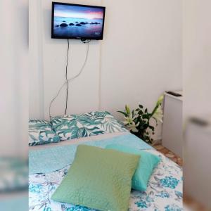 1 dormitorio con 1 cama y TV en la pared en Studio Verde-Coral Copacabana, en Río de Janeiro